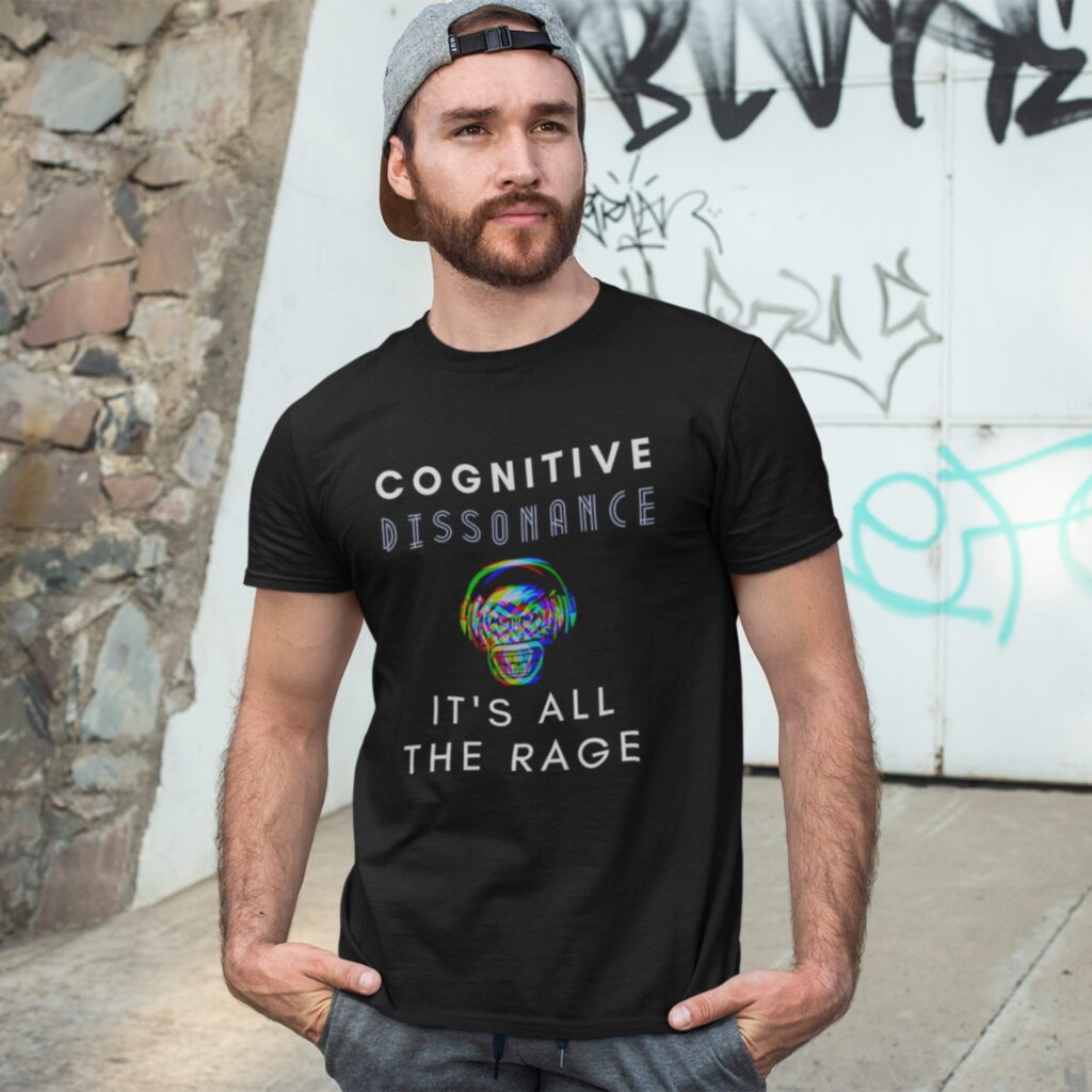 Cognitive Dissonance All The Rage t-shirt worn by a man against a graffiti wall.
