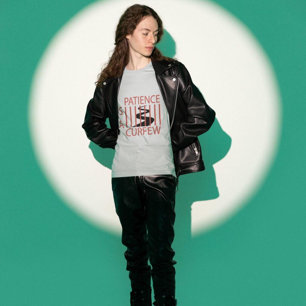 Patience Is A Curfew t-shirt worn by a young man.