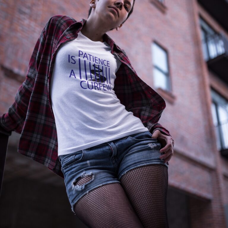 Patience Is A Curfew t-shirt worn by a woman.