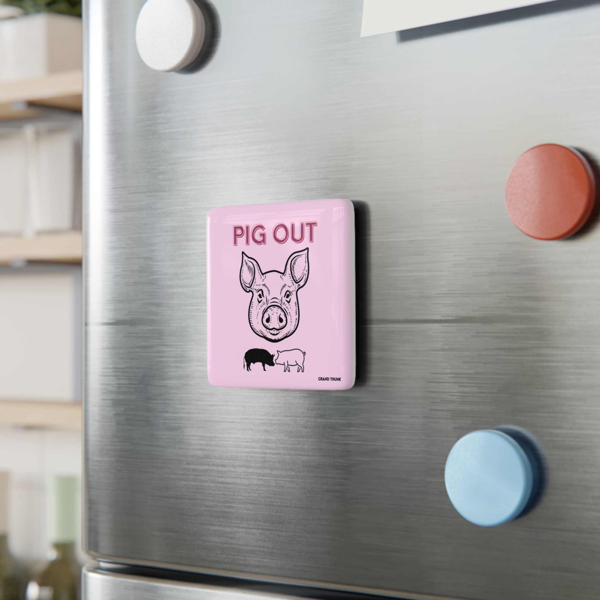 Piggy Pig Out refrigerator magnet on a metal refrigerator door.