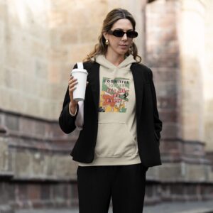 Deco Jungle sand colored hoodie worn by a woman walking with a coffee.